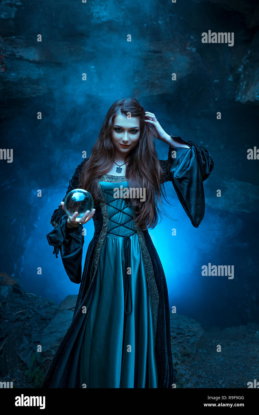 The witch with magic ball in her hands causes a spirits Stock Photo