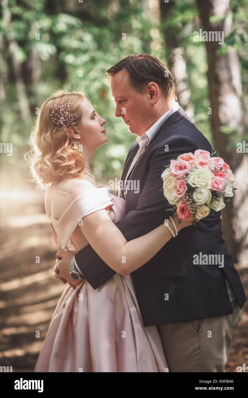 bride and groom on the background of trees and forest sun Stock Photo ...