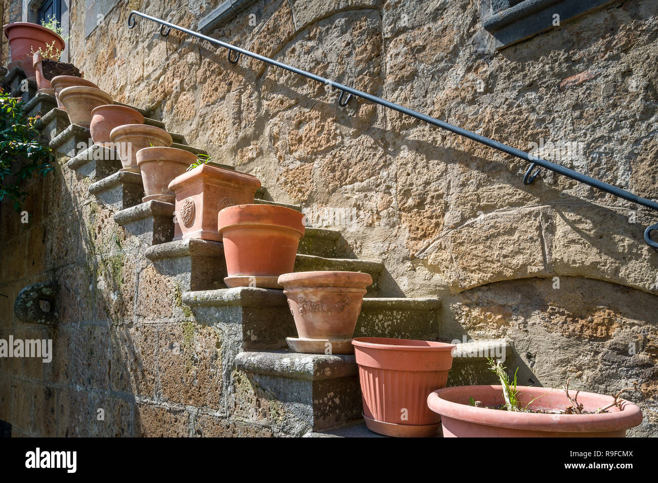Flower pots at the steps of Civita di Bagnoregio old house. Tuscany, Italy. Stock Photo