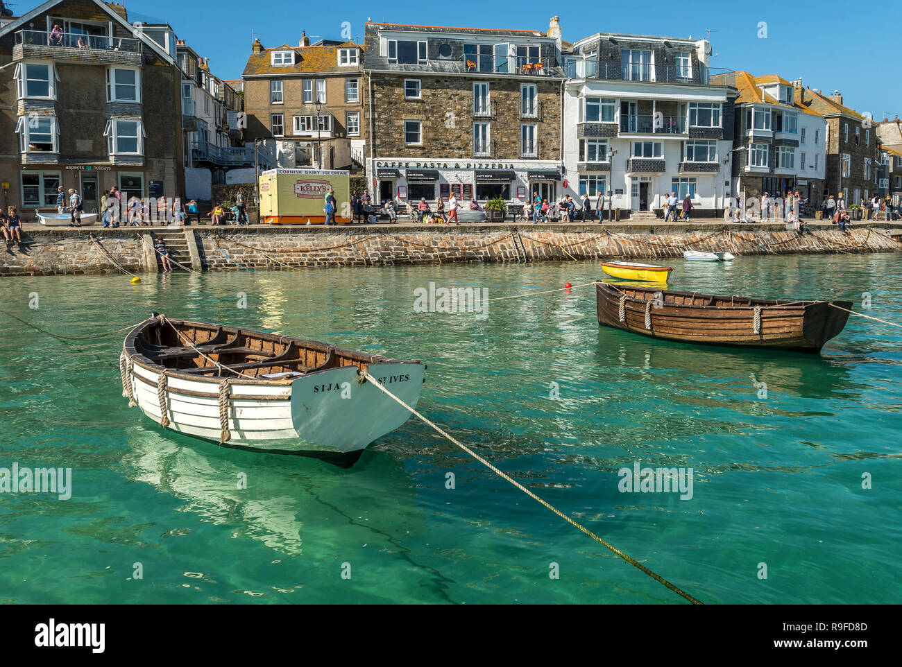 Traditional wooden punts on moorings in crystal clear waters of St.ives harbour St.ives Cornwall UK Stock Photo