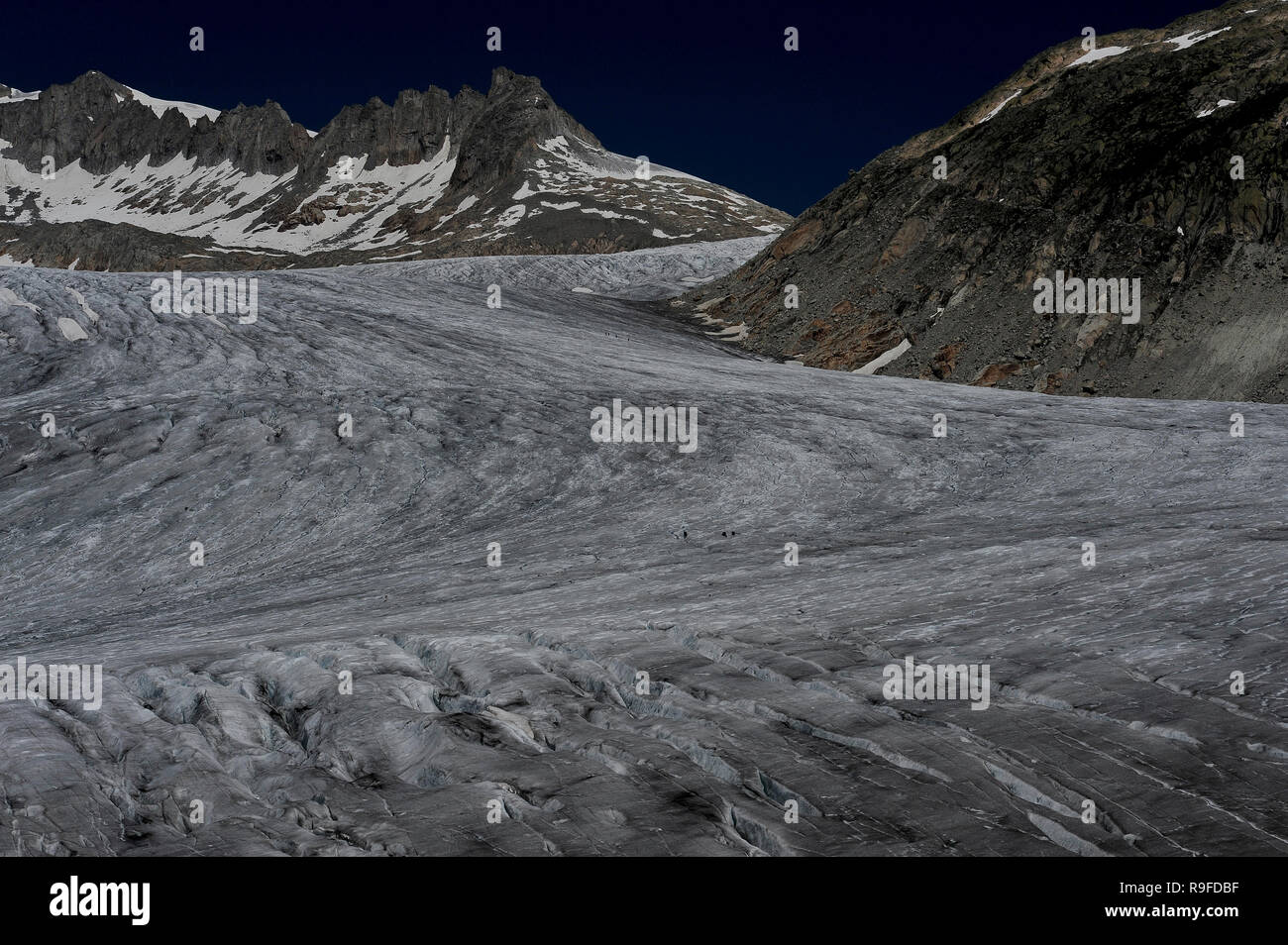 Rhône Glacier, Valais canton, Switzerland: scientists measure glacial shrinkage far out on the deeply fissured ice flowing from the Tieralplistock. Stock Photo