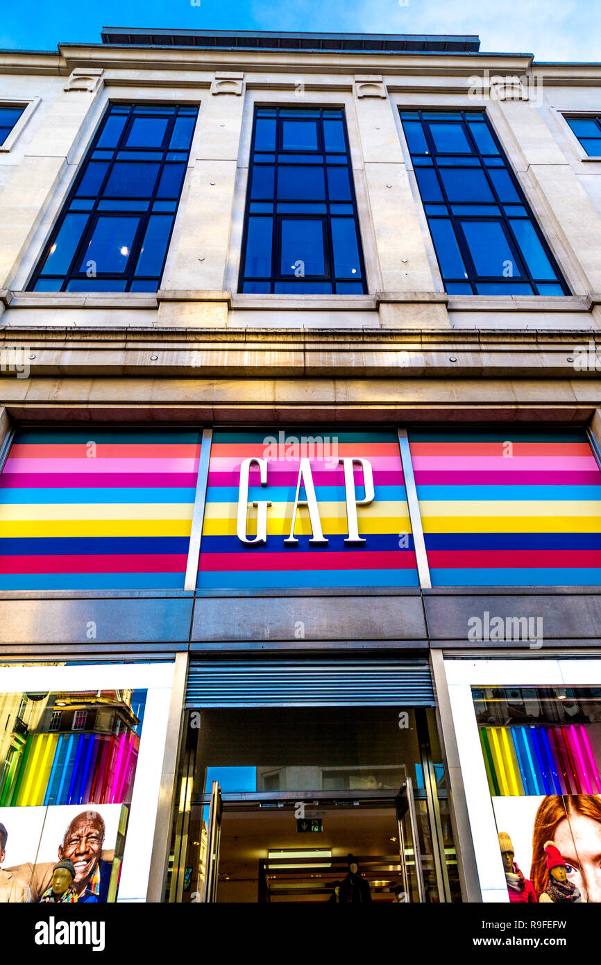 Front of the GAP store on Oxford Street with brand logo and rainbow colours background, London, UK Stock Photo