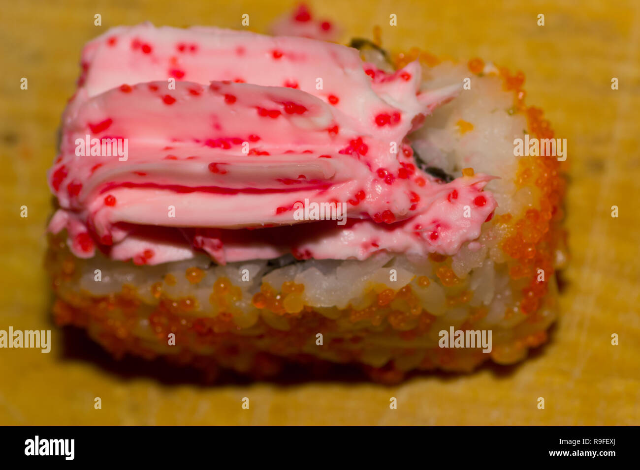 Sushi roll with salmon, cucumber, cream cheese, caviar tobiko and masago on wooden background Stock Photo