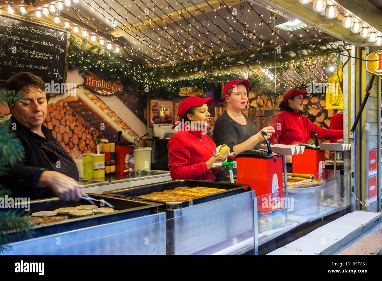 Street vendors in fastfood stand selling hamburgers at Christmas market in winter in the city Ghent, Flanders, Belgium Stock Photo