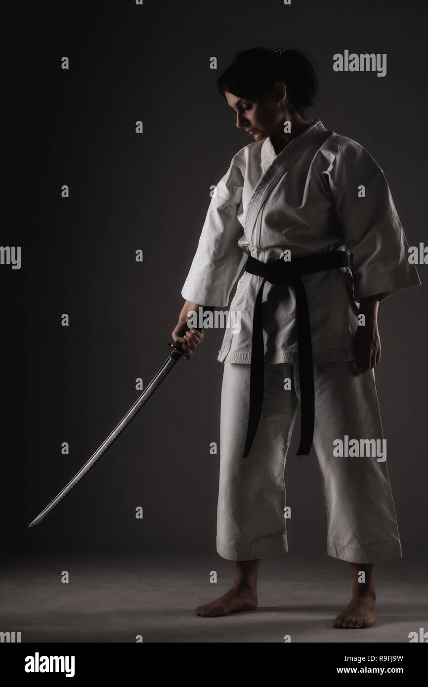 karate girl with a sword against dark background Stock Photo Alamy