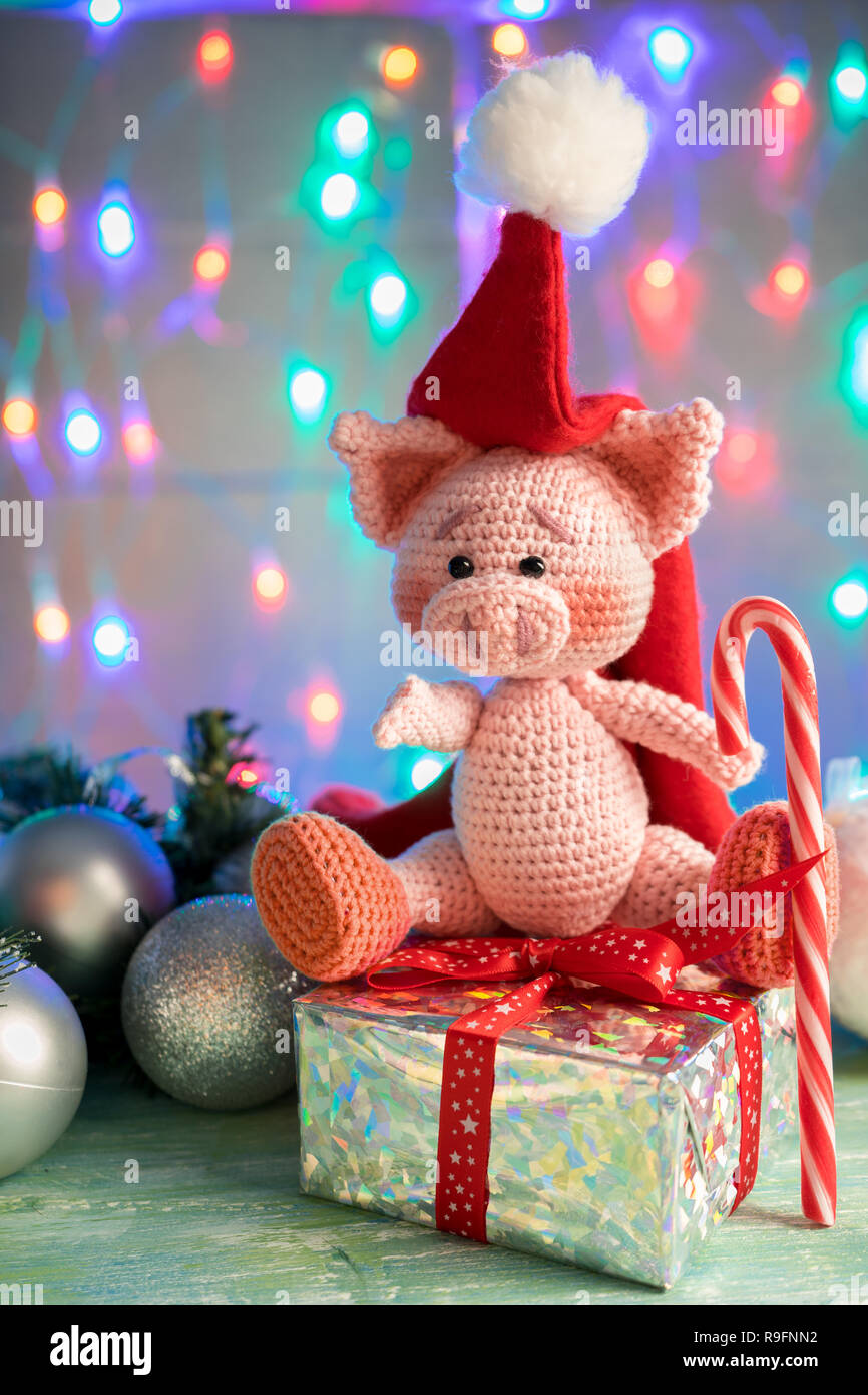 symbol 2019 pink pig sitting on a gift with candy cane on background with illumination. Stock Photo