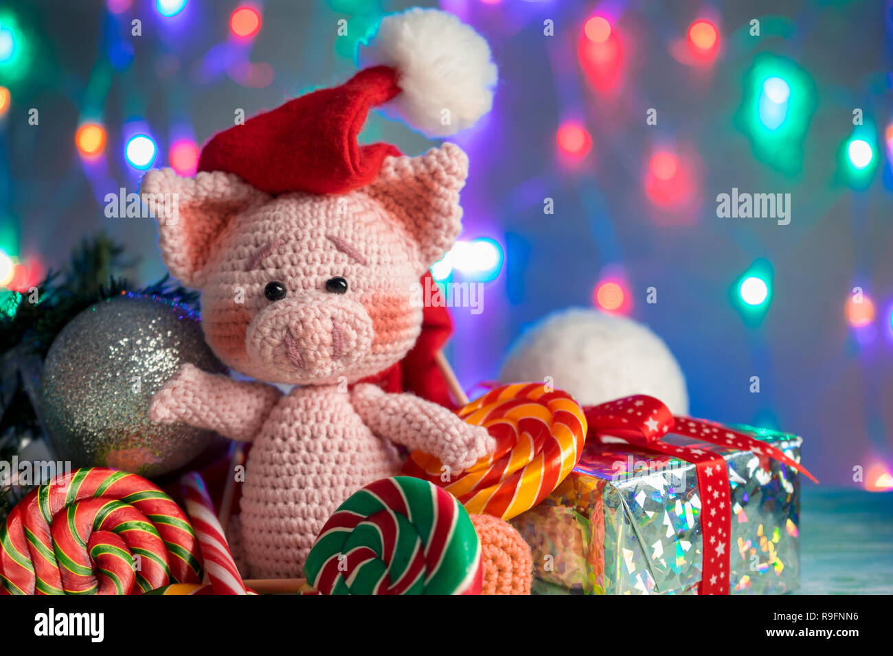 Funny greeting card with new year 2019. Pink pig with lollipops closeup on background with illumination. Stock Photo