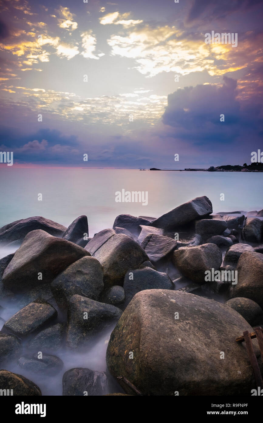 Sunrise at Bintan Island. Sand sea sky clouds and stones Stock Photo