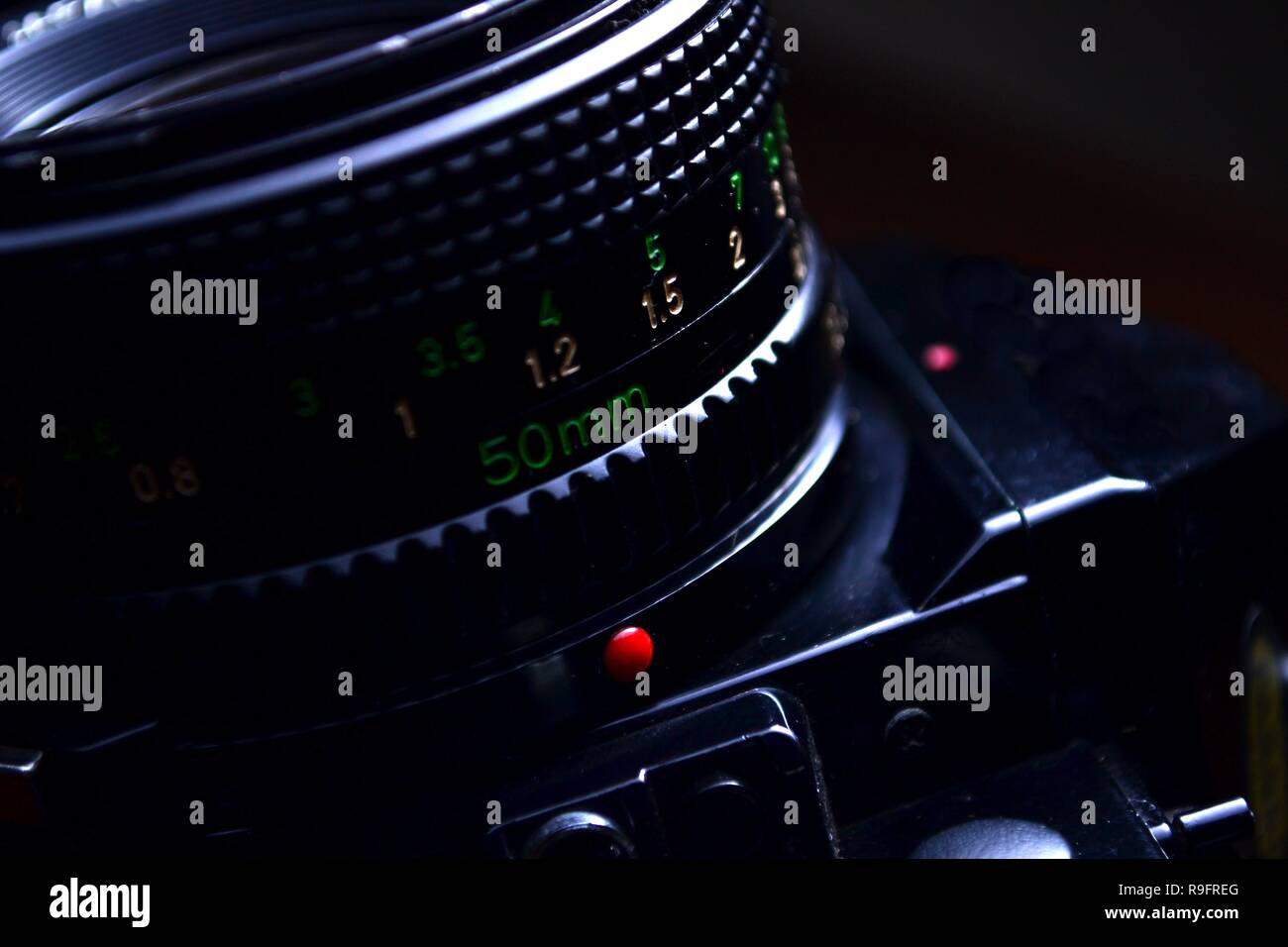 close up shot of the focus ring focus distance scale and aperture ring of a manual lensof a 35mm film camera R9FREG