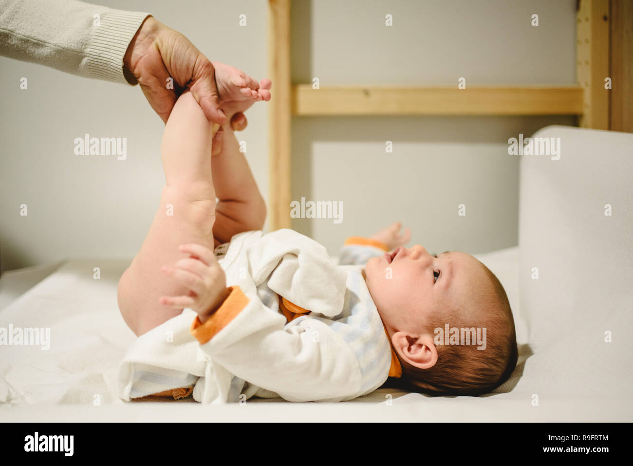Mother changing diaper to baby, lifting her little legs Stock Photo Alamy