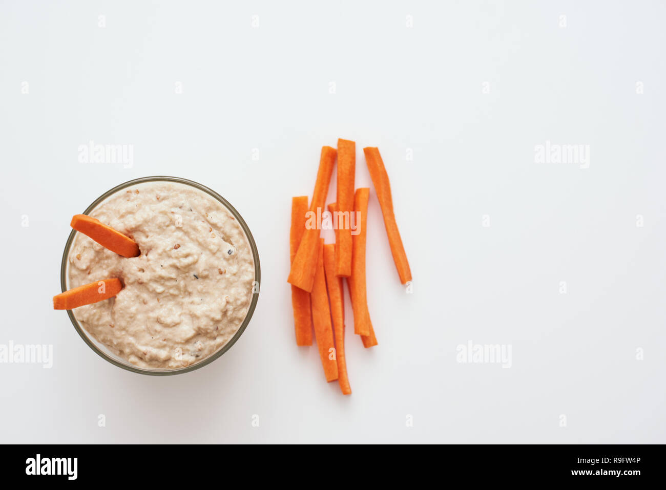 Quick snack. Hummus with carrot sticks. Top view of humus with loaves ...