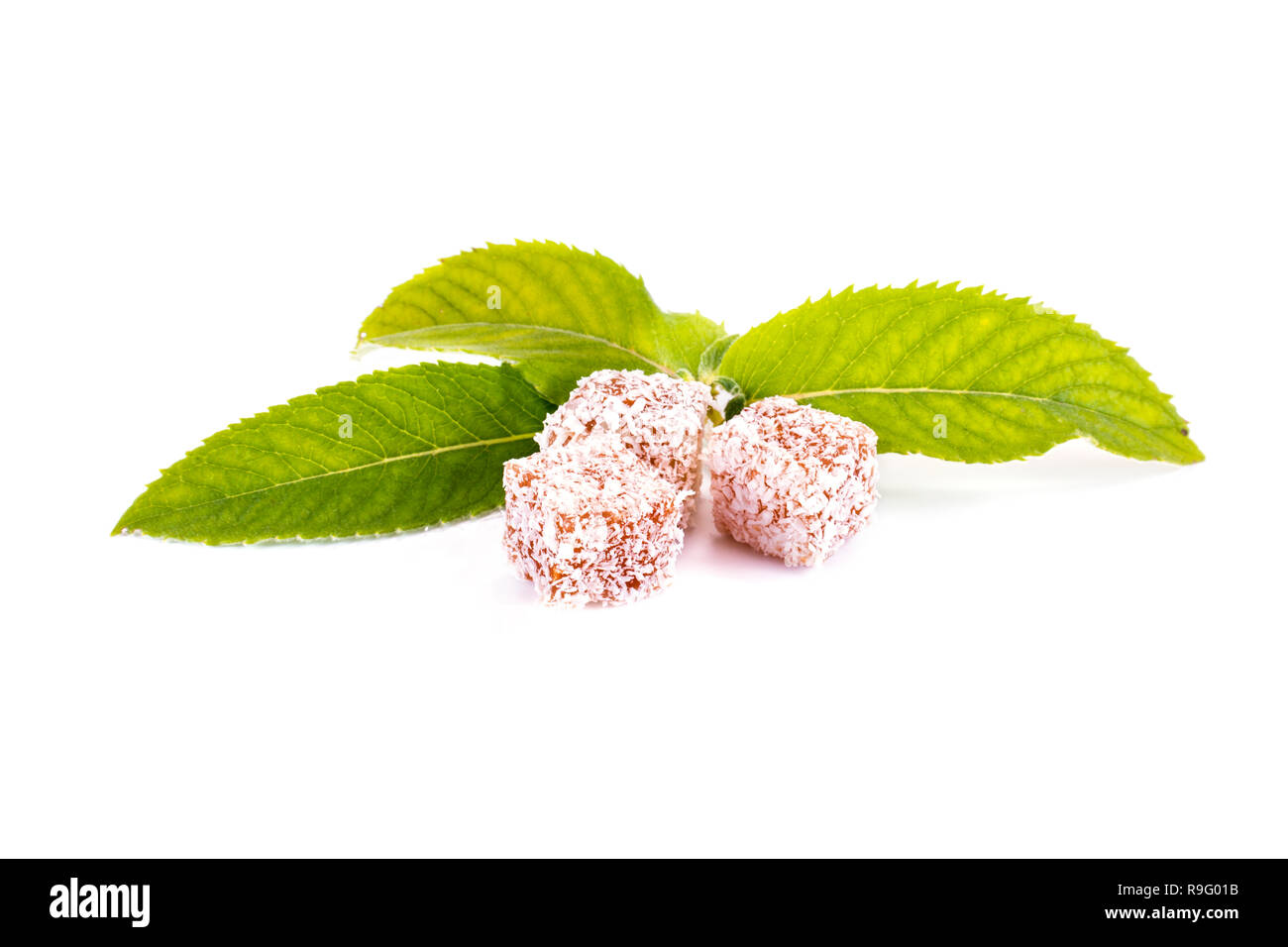 Slices of delicacy Turkish delight with coconut chips and mint leaves isolated on white background Stock Photo