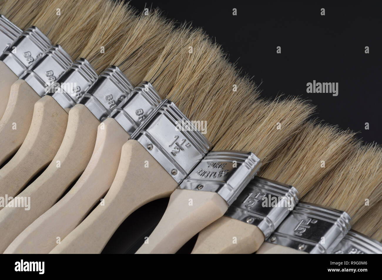 Close-up natural bristle wooden paintbrushes / paint brushes - metaphor for home decoration / decorating, painted in broad strokes, painting. Stock Photo