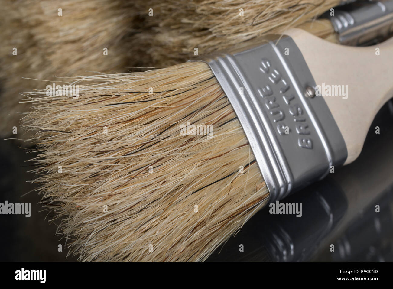 Close-up of natural bristle wooden paintbrushes / paint brushes - metaphor for home decoration / decorating, painted in broad strokes, painting. Stock Photo