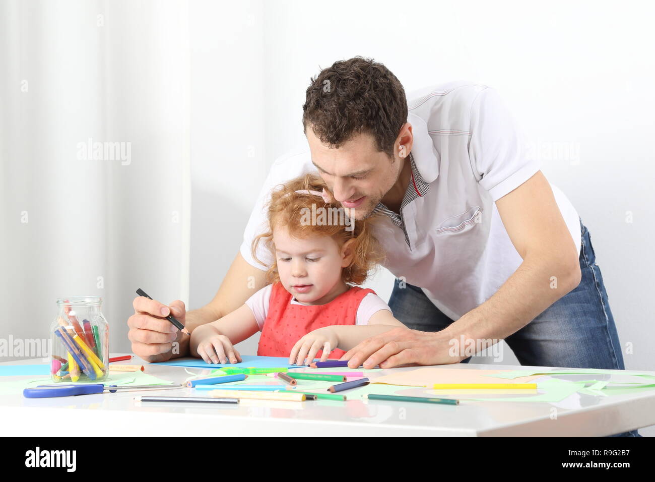 A male educator or a vather doing painting together Stock Photo