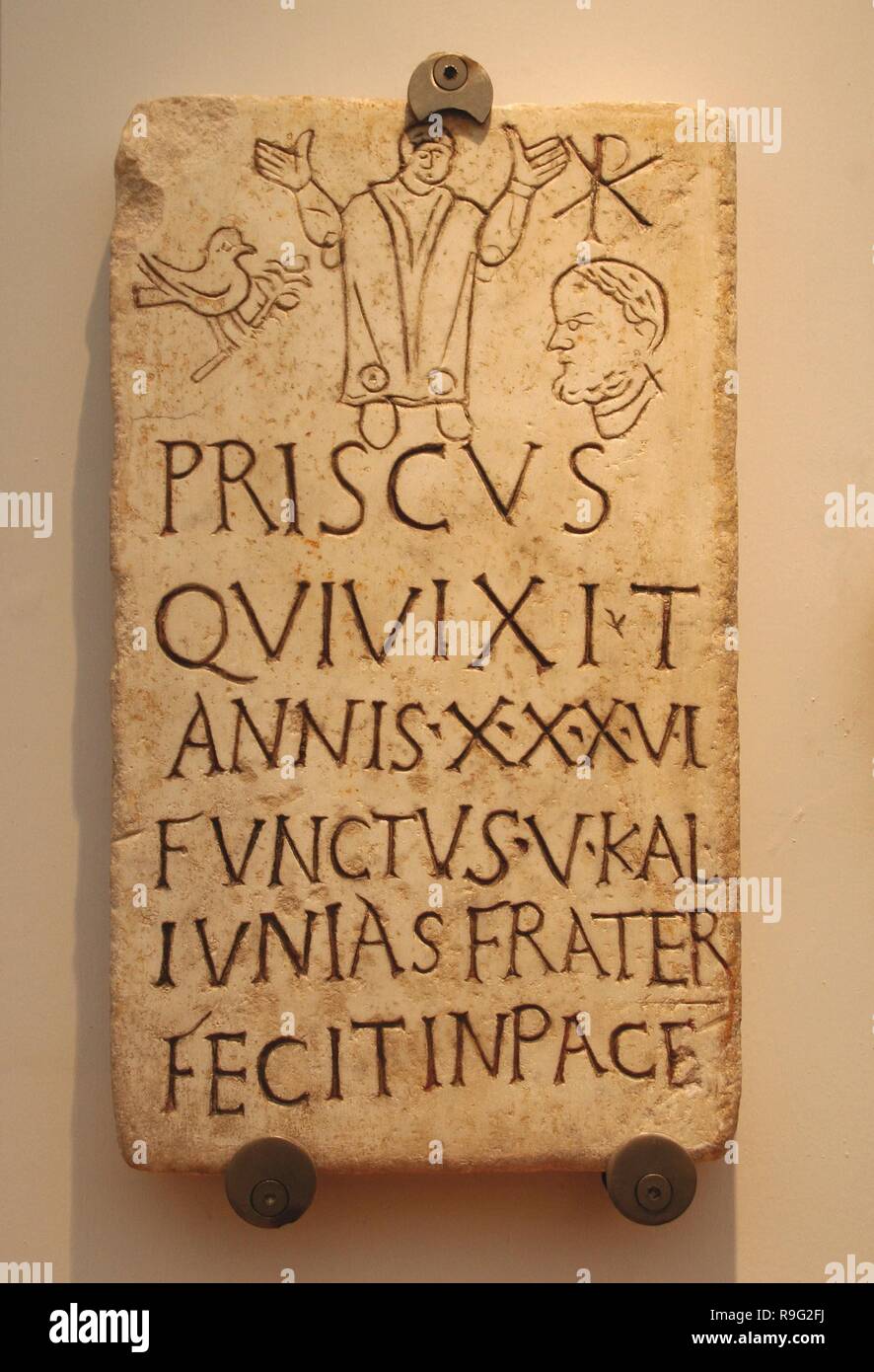 Italy. Early Christians. Roman funerary stele of Prisco. Inscription: Christian phrase appears 'in pace'. The symbol of the dove and the olive branch and the monogram of Constantine T. 4th century AD. Baths of Diocletian, part of the National Roman Museum Rome. Italy. Stock Photo