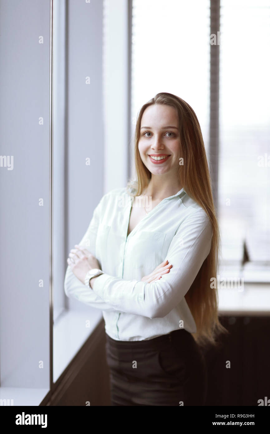 business woman standing near the window in the corridor of the office. Stock Photo