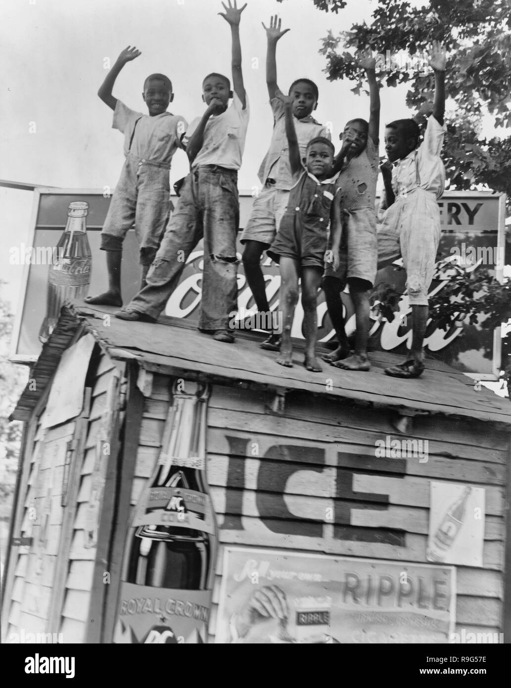 Colored boys playing on top of Coca Cola stand. Little Rock, Arkansas - June 1938 Stock Photo