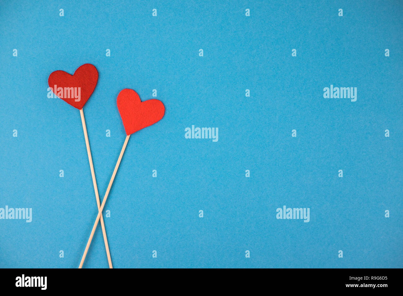 Two felt hearts on a blue background. Stock Photo