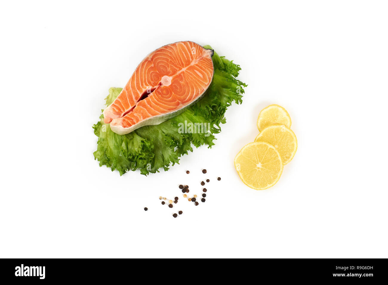 steak of a red fish salmon with lemon and pepper, isolated on white ...