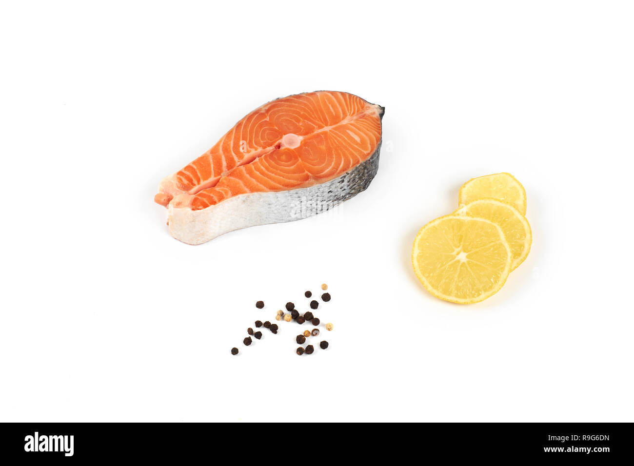 steak of a red fish salmon with lemon and pepper, isolated on white ...
