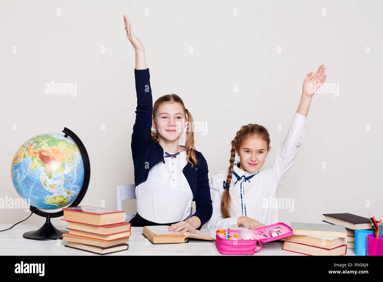 two girls in the classroom Learn lesson books at her desk globe Stock ...