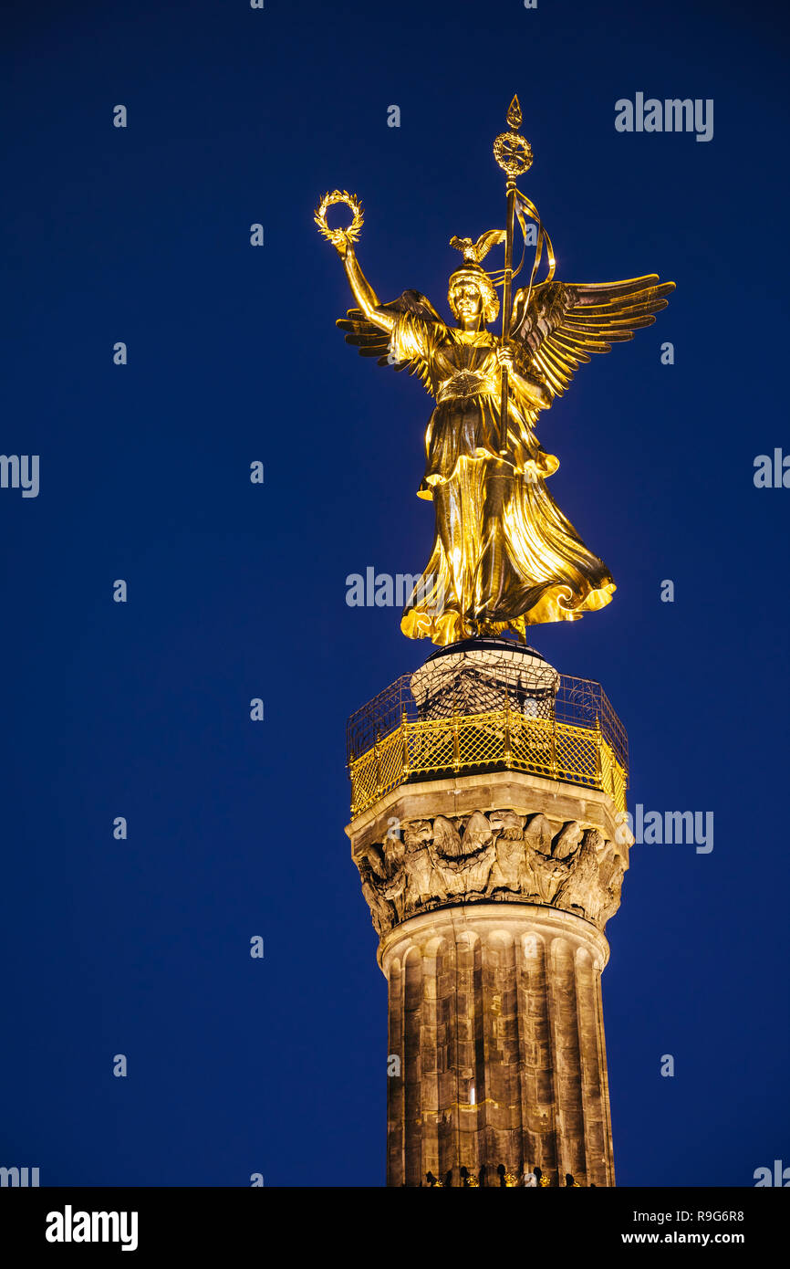 Illuminated golden statue of Victoria on top of the Berlin Victory