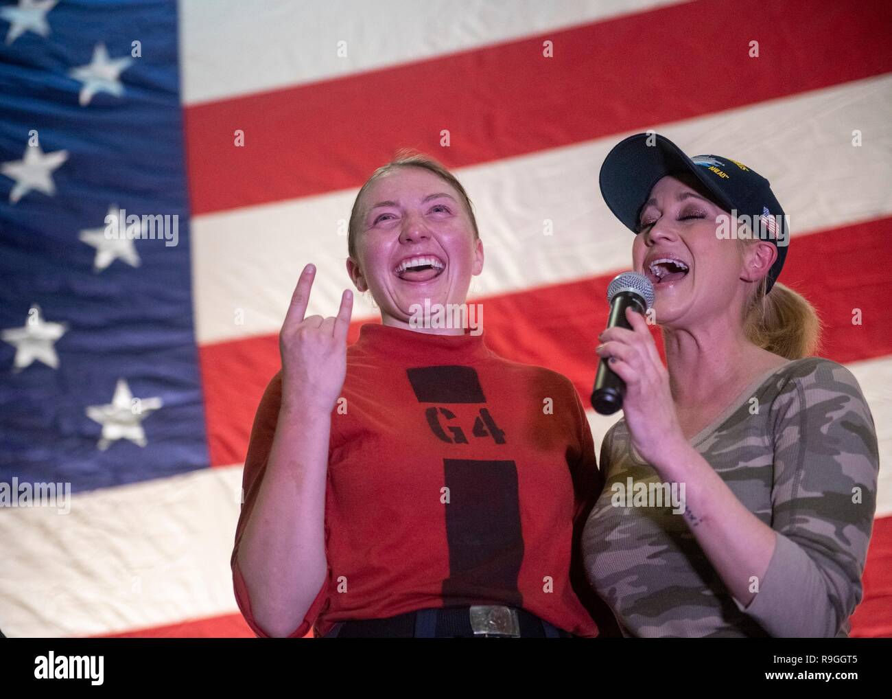 Country Music Singer Kellie Pickler, right, performs with a sailor during the Joint Chiefs USO Christmas Show for deployed service members aboard the aircraft carrier USS John C. Stennis  December 23, 2018 in the Persian Gulf. This year’s entertainers include actors Milo Ventimiglia, Wilmer Valderrama, DJ J Dayz, Fittest Man on Earth Matt Fraser, 3-time Olympic Gold Medalist Shaun White, Country Music Singer Kellie Pickler, and comedian Jessiemae Peluso. Stock Photo