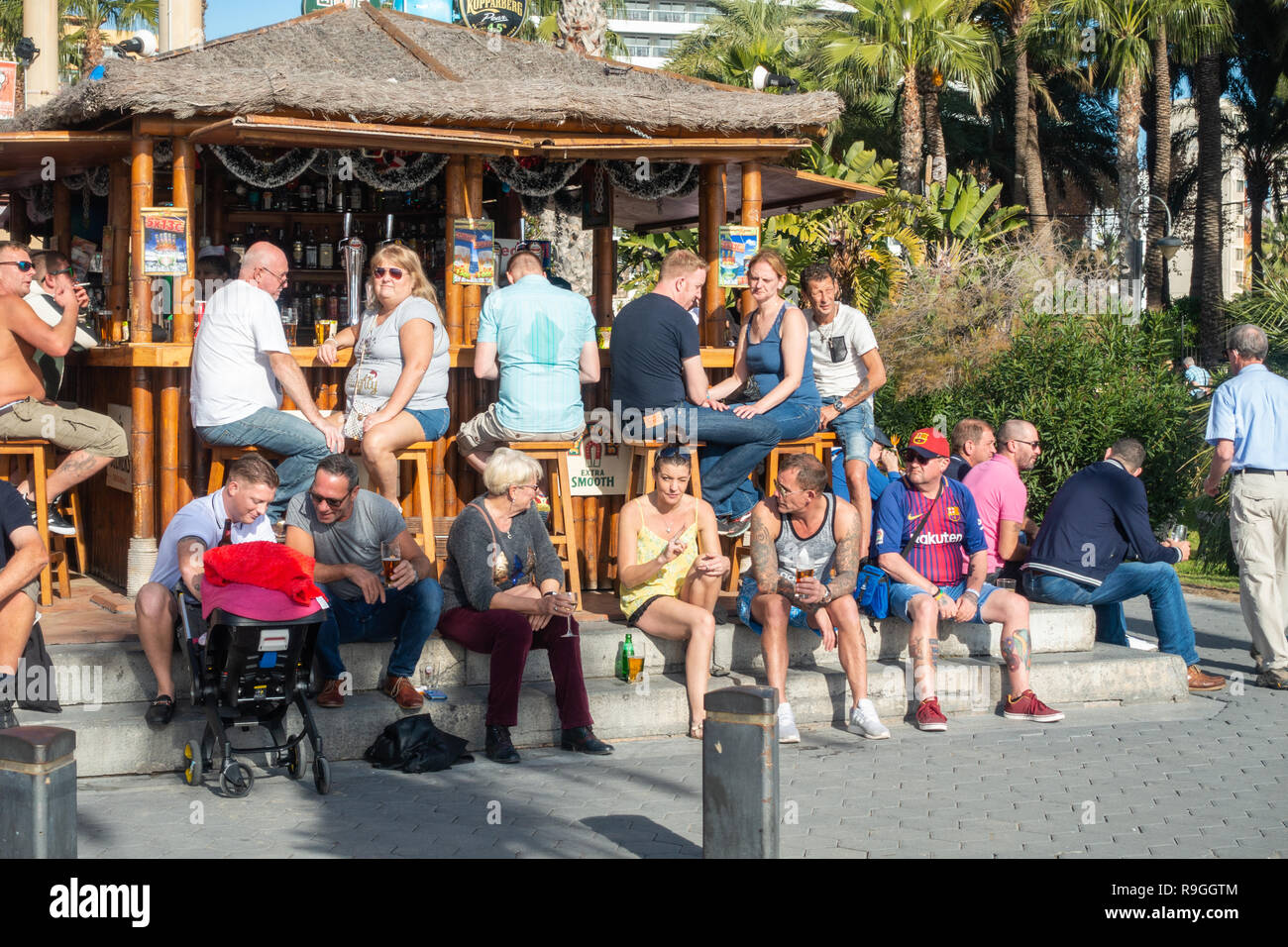 Benidorm, Costa Blanca, Spain, 24th December 2018. British holidaymakers escaping from the cold weather back home flood this popular resort during the Christmas holidays. Drinkers enjoy the hot temps and calm weather at the famous Tiki Beach Bar on Levante beach today in Benidorm on the Costa Blanca coast. Temperatures were in the mid to high 20's Celsius today in this Mediterranean hotspot. Credit: Mick Flynn/Alamy Live News Stock Photo