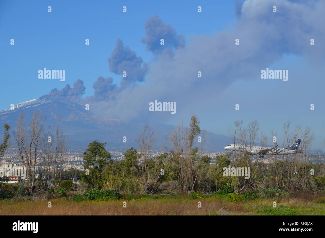 Catania, Sicily, Italy. 24th December, 2018. A plane landing near Europe's most active volcano, Mount Etna, in eruption in the afternoon. Credit: jbdodane/Alamy Live News Stock Photo