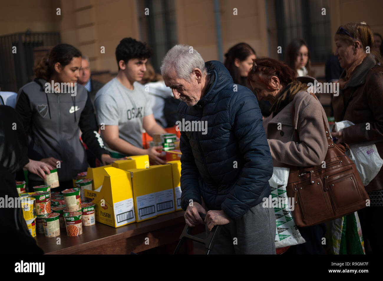 Malaga, Spain. 24th Dec, 2018. An elderly man seen receiveing food from volunteers during the annual charity distribution of food by the NGO 'Ángeles Malagueños de la Noche' (Malaga's Angels of the Night). This organization distribute every 24th of December on Christmas eve hundreds of food to needy people in the city. Credit: SOPA Images Limited/Alamy Live News Stock Photo