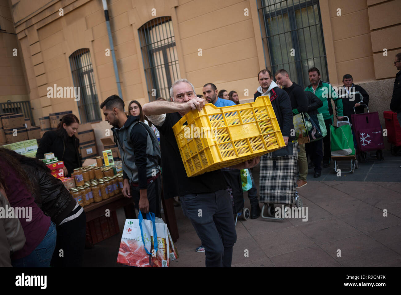 Malaga, Spain. 24th Dec, 2018. A volunteer is seen carrying a box with food  during the annual charity distribution of food by the NGO "Ángeles  Malagueños de la Noche" (Malaga's Angels of