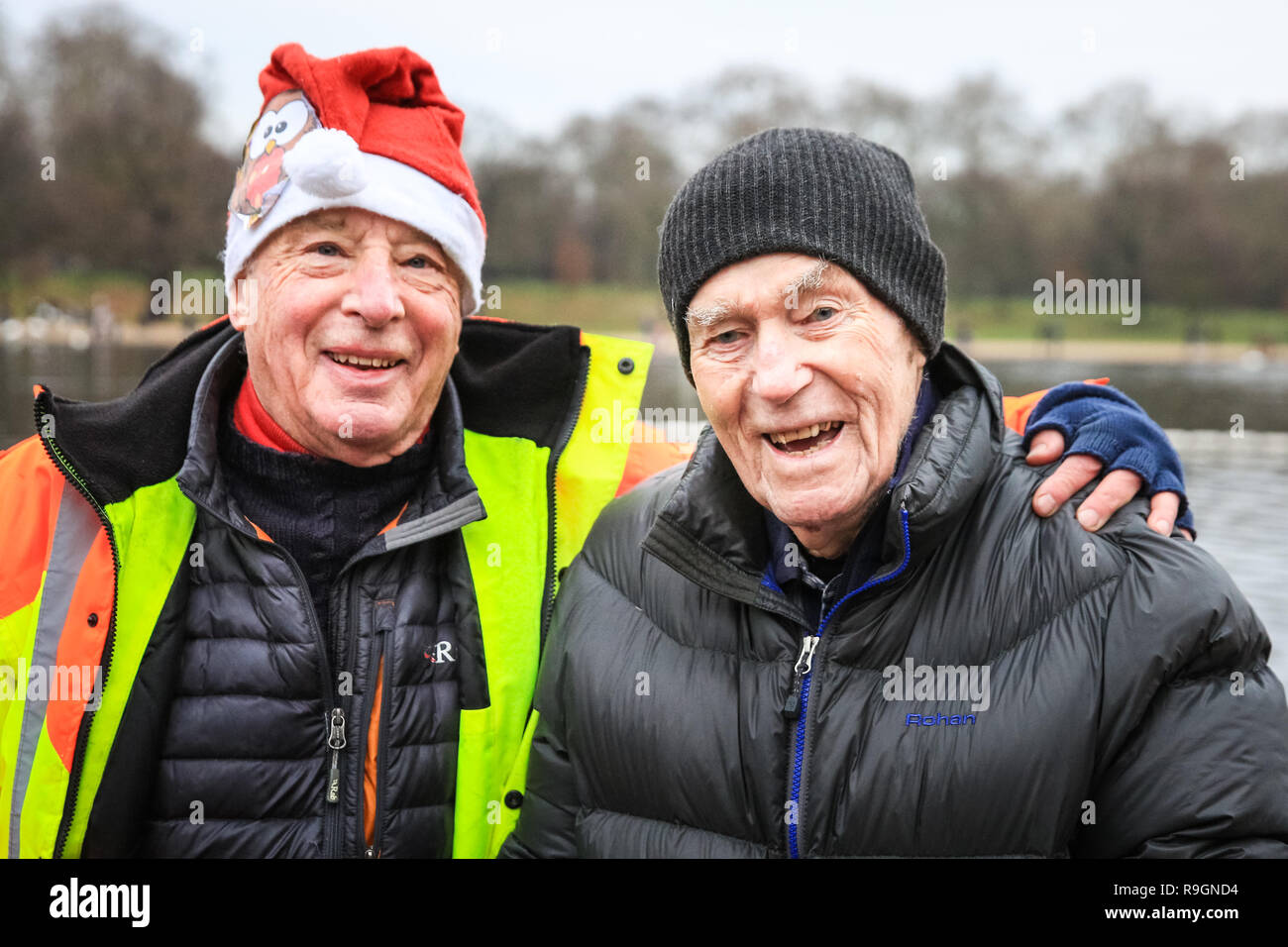 Hyde Park, London, 25th Dec 2018. The Serpentine Club President with the Club's oldest member, Alan Lacy, who is 95 and in good spirits. The 154th annual Christmas morning race for the 'Peter Pan Cup' gets under way at the Serpentine Swimming Club in London's Hyde Park. Swimmers brave the wintry weather and freezing cold open water of the Serpentine for the traditional event. Credit: Imageplotter News and Sports/Alamy Live News Stock Photo