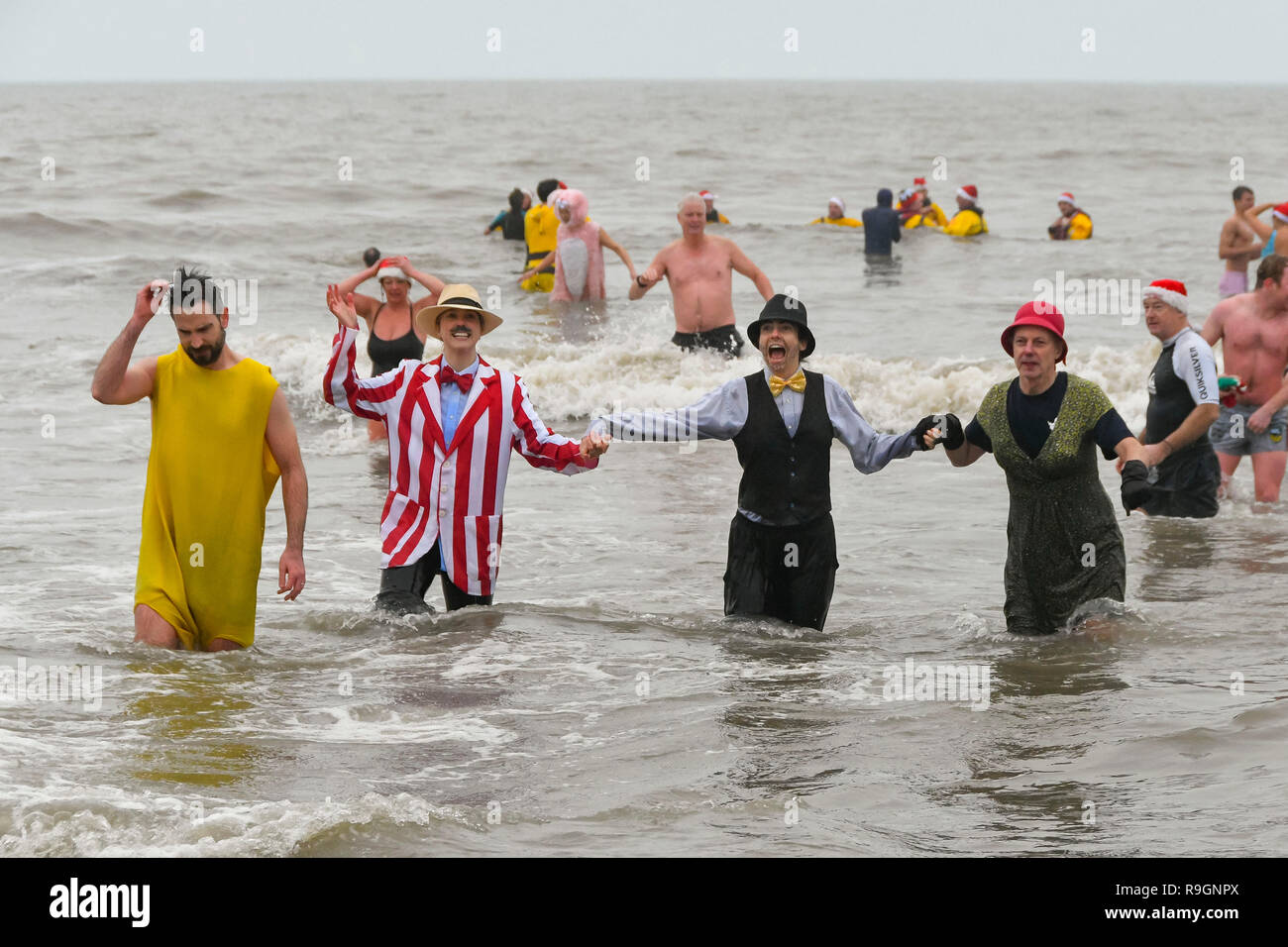 Charmouth, Dorset, UK. 25th Dec, 2018. Christmas day swimmers wearing fancy dress braving the chilly water to take a dip in the sea at Charmouth in Dorset to raise money for the RNLI. Picture Credit: Graham Hunt/Alamy Live News Stock Photo