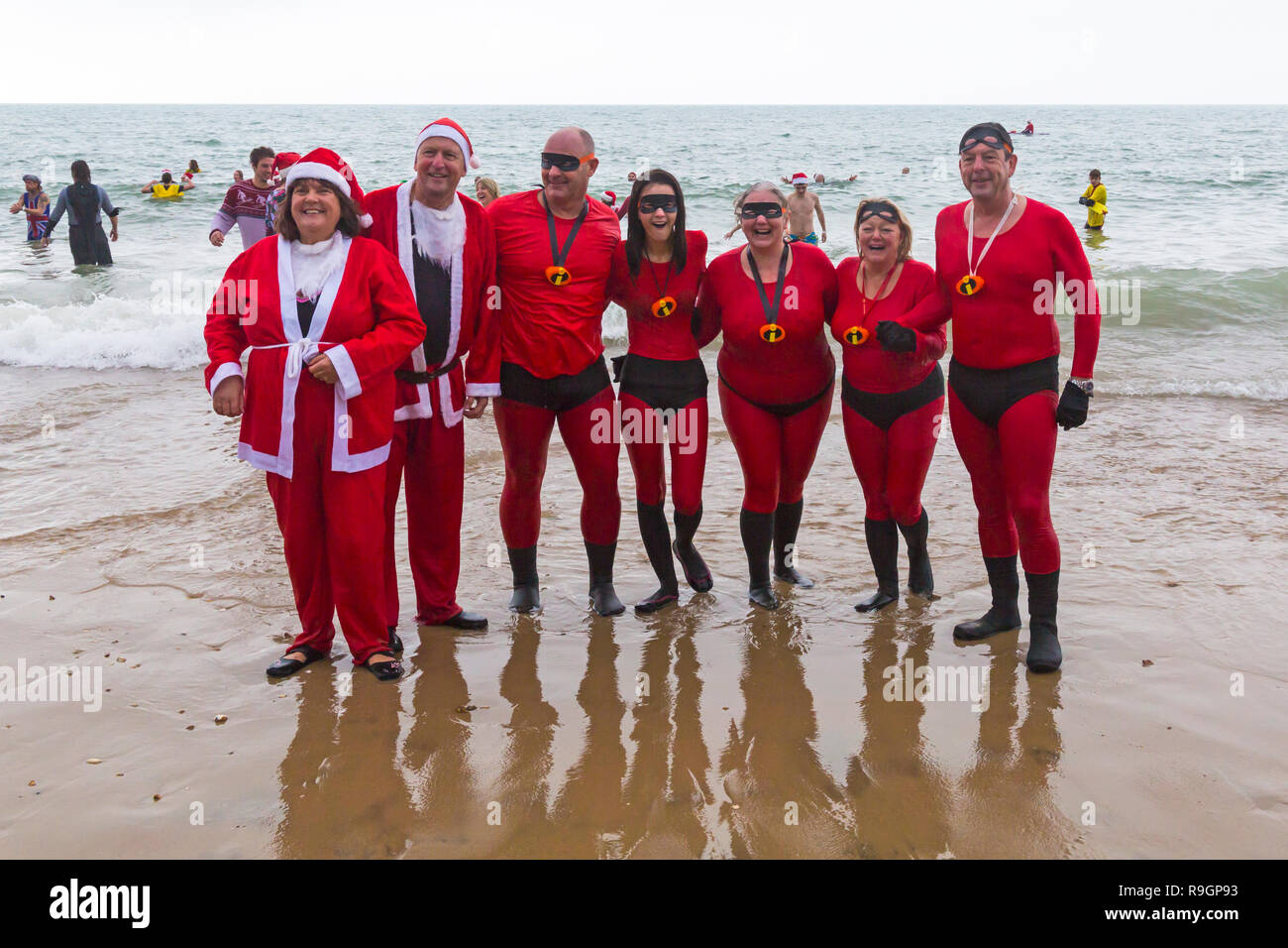 Boscombe, Bournemouth, Dorset, UK. Christmas Day 25th December 2018. Brave volunteers plunge into the cold choppy sea for a swim, for the annual charity White Christmas Dip, dressed in fancy dress costumes and raising money for Macmillan Caring Locally at Christchurch, a Specialist Palliative Care Unit for patients in the local community. Hundreds take part in the event which has become a popular tradition for many before their Christmas lunch. Credit: Carolyn Jenkins/Alamy Live News Stock Photo