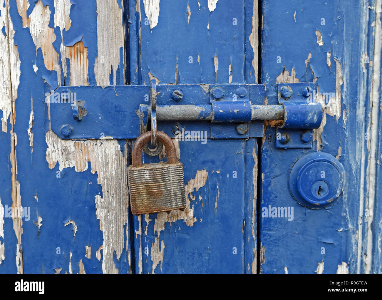 Blue bolted door with peeling paint, padlock, Bridgwater, Somerset, South West England, UK Stock Photo