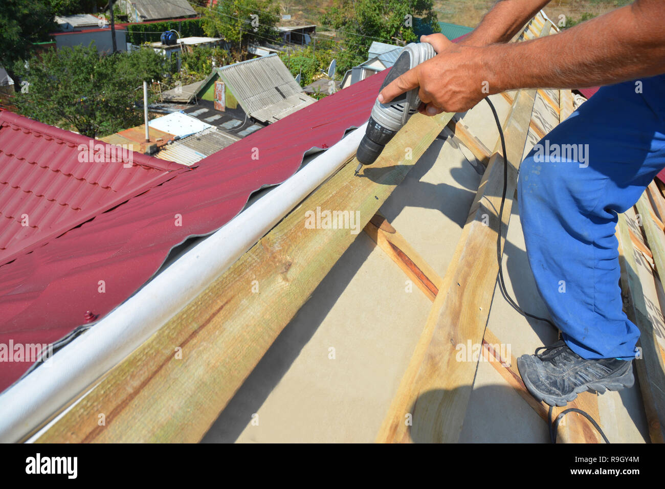 Roofing construction. Roofer contractor installing wooden beams on