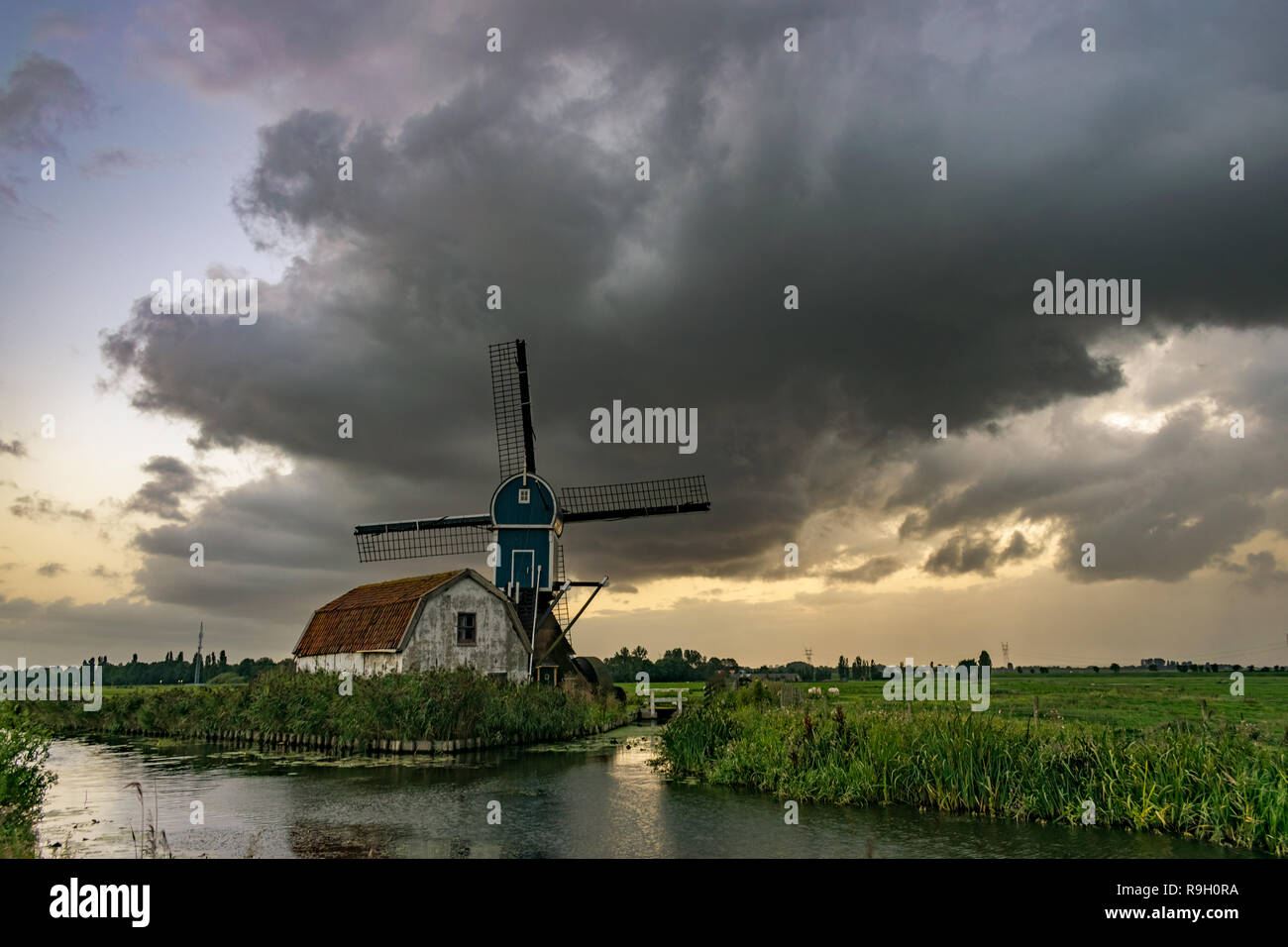 A dutch windmill under a dramatic sky. The outflow of a thunderstorm moves over the Green Heart of Holland near the cities of Leiden and Gouda. Stock Photo