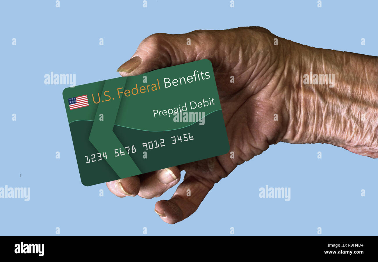 An elderly hand holds an insurance or benefits card such as social security ssi payment debit card Stock Photo