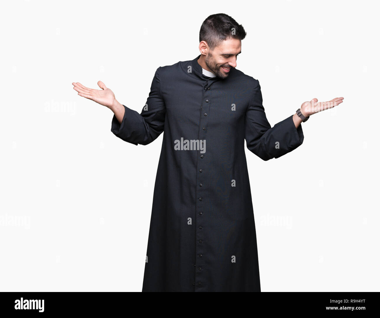 Young Christian priest over isolated background Smiling showing both ...