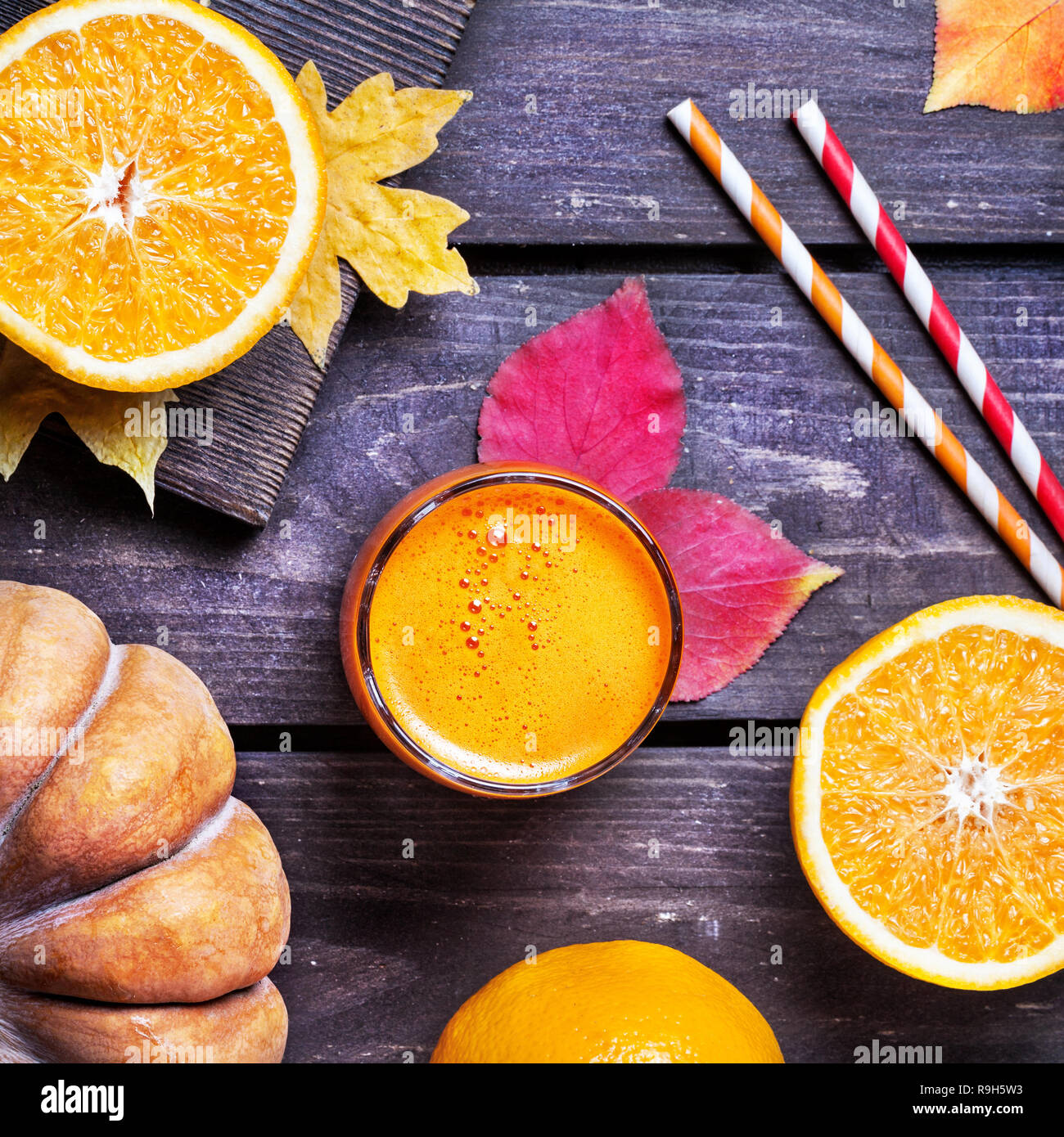 Fresh pumpkin and oranges juice on wooden background in autumn season Stock Photo