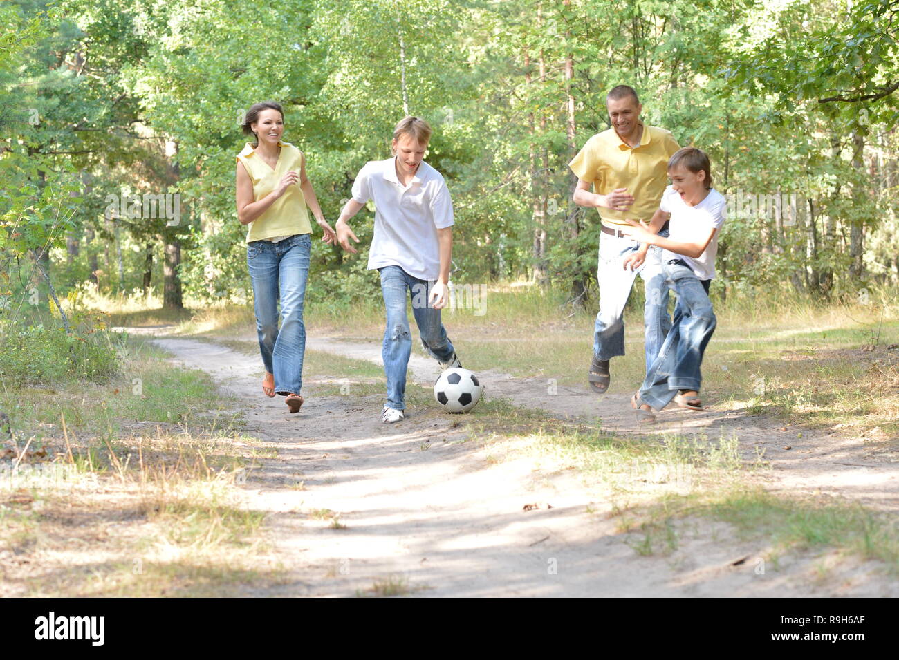Cute happy family playing soccer in park Stock Photo - Alamy