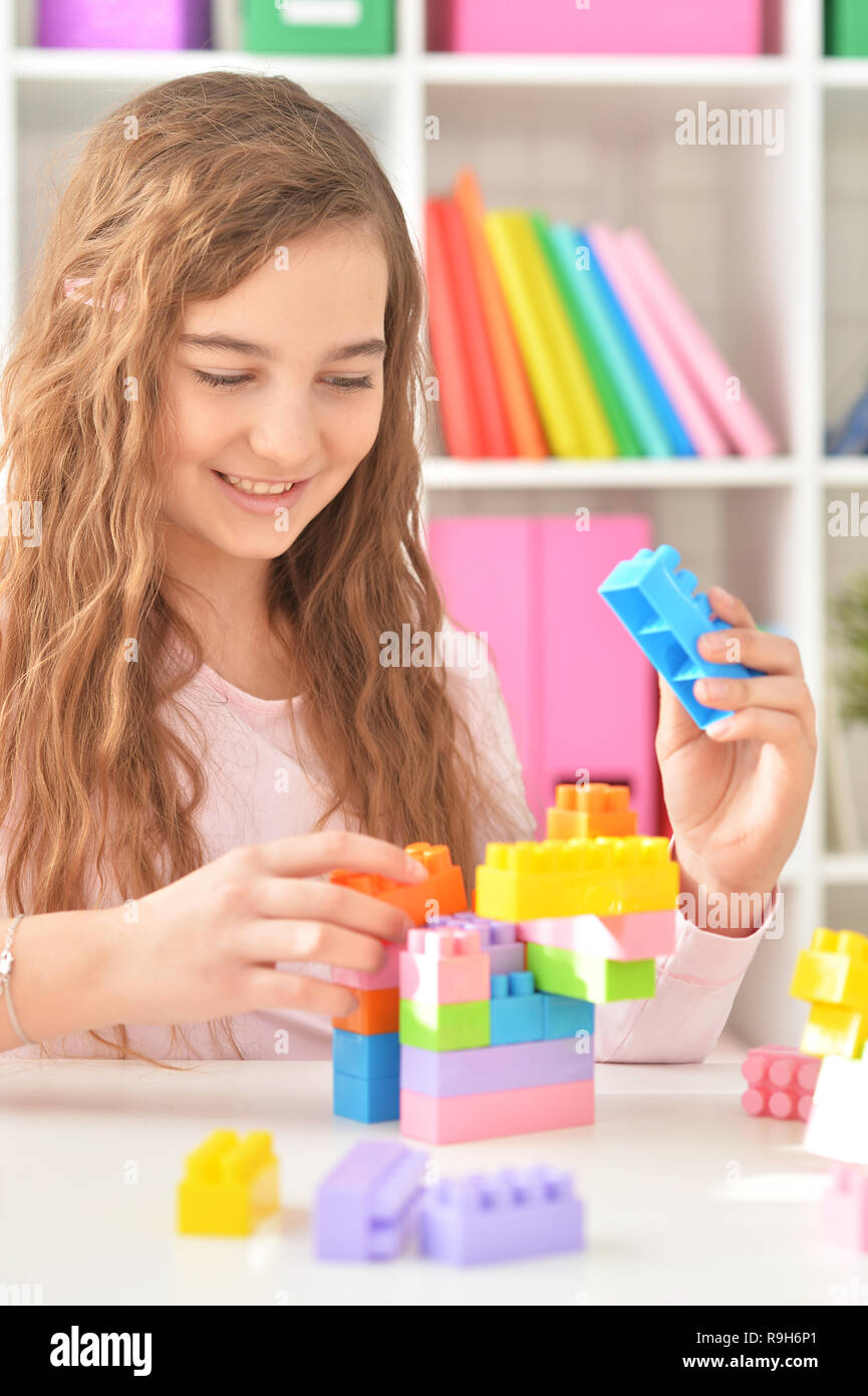 Curly teen girl playing with colorful plastic blocks Stock Photo - Alamy