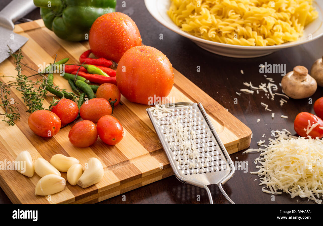kitchen table preparation with pasta and ingredients on chopping board ...