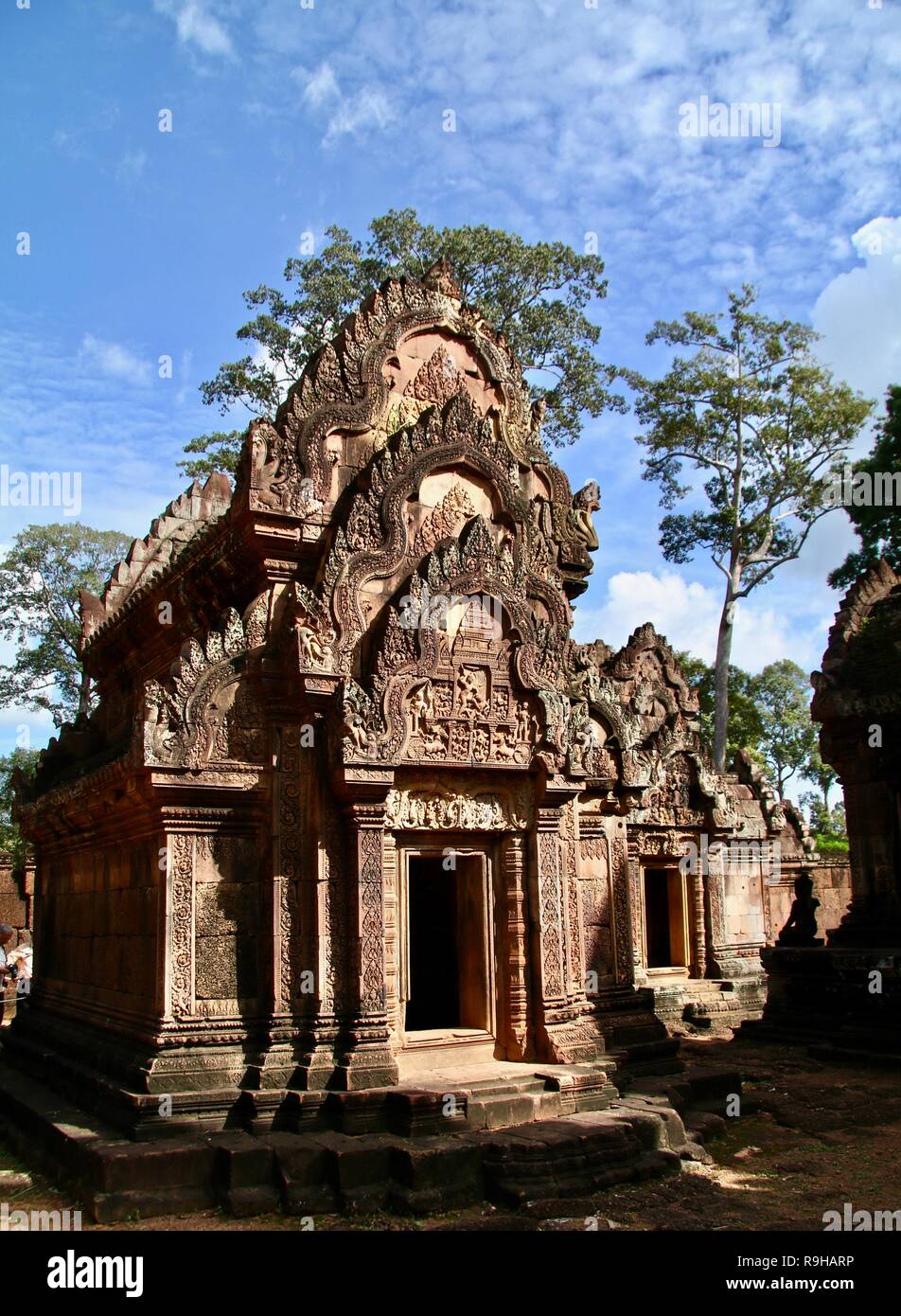 The front of a an old stone carved temple in the jungles of Cambodia