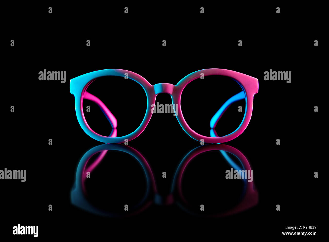 Stylish sunglasses shot using pink and blue abstract colored lighting with copy space. Stock Photo