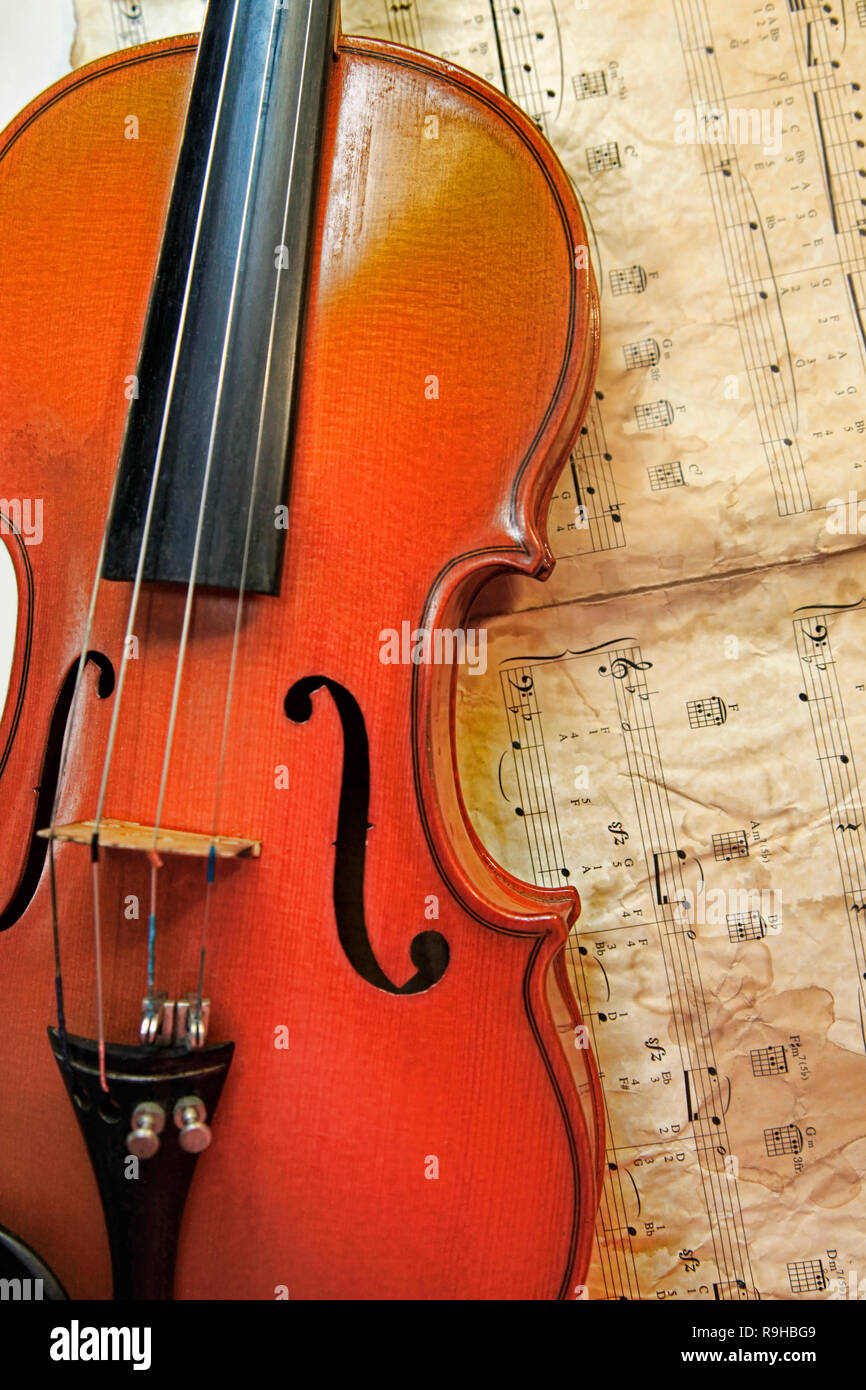 1937 old violin on the background of notes Stock Photo