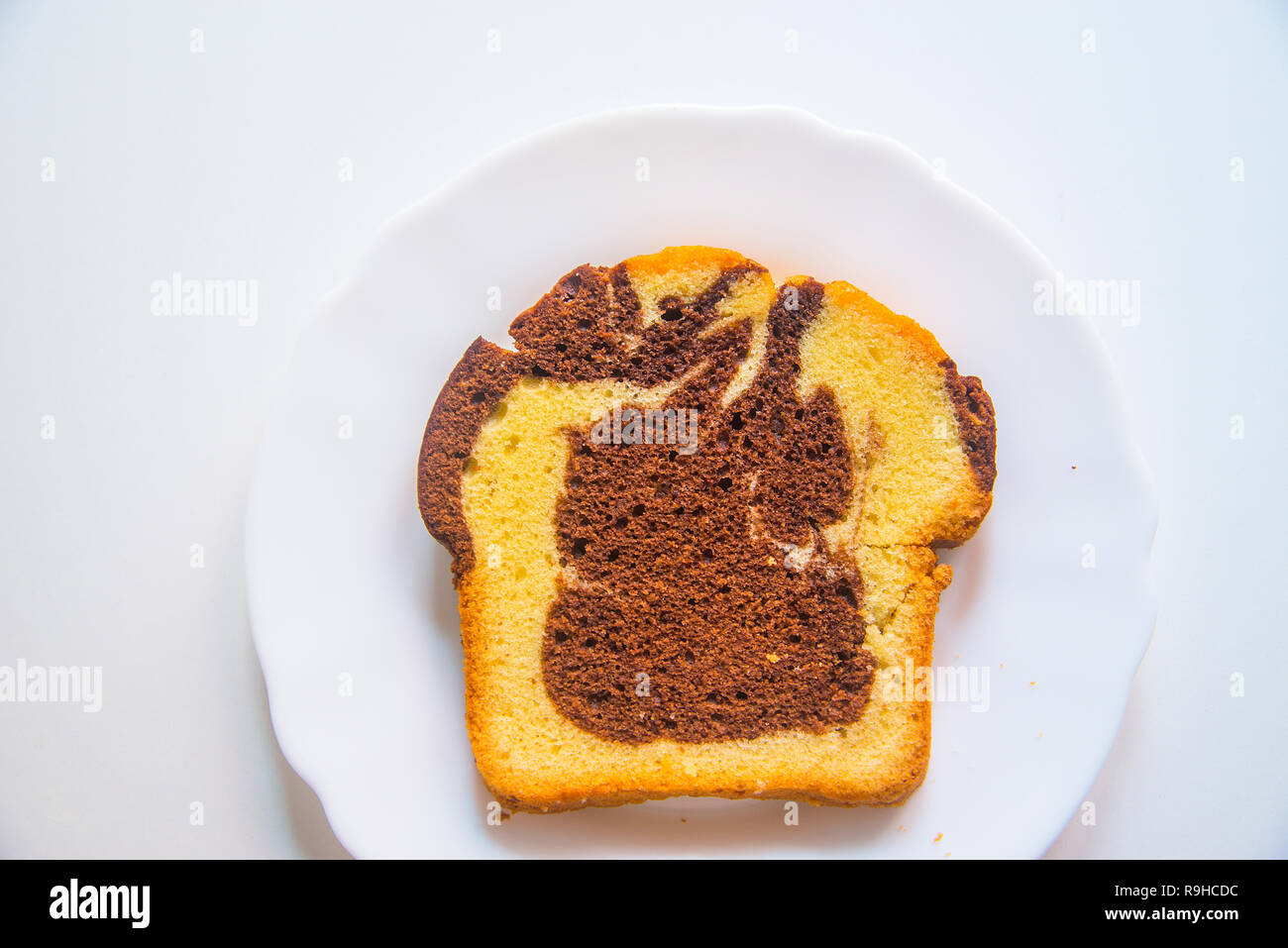 Piece of sponge cake on a dish. View from above. Stock Photo