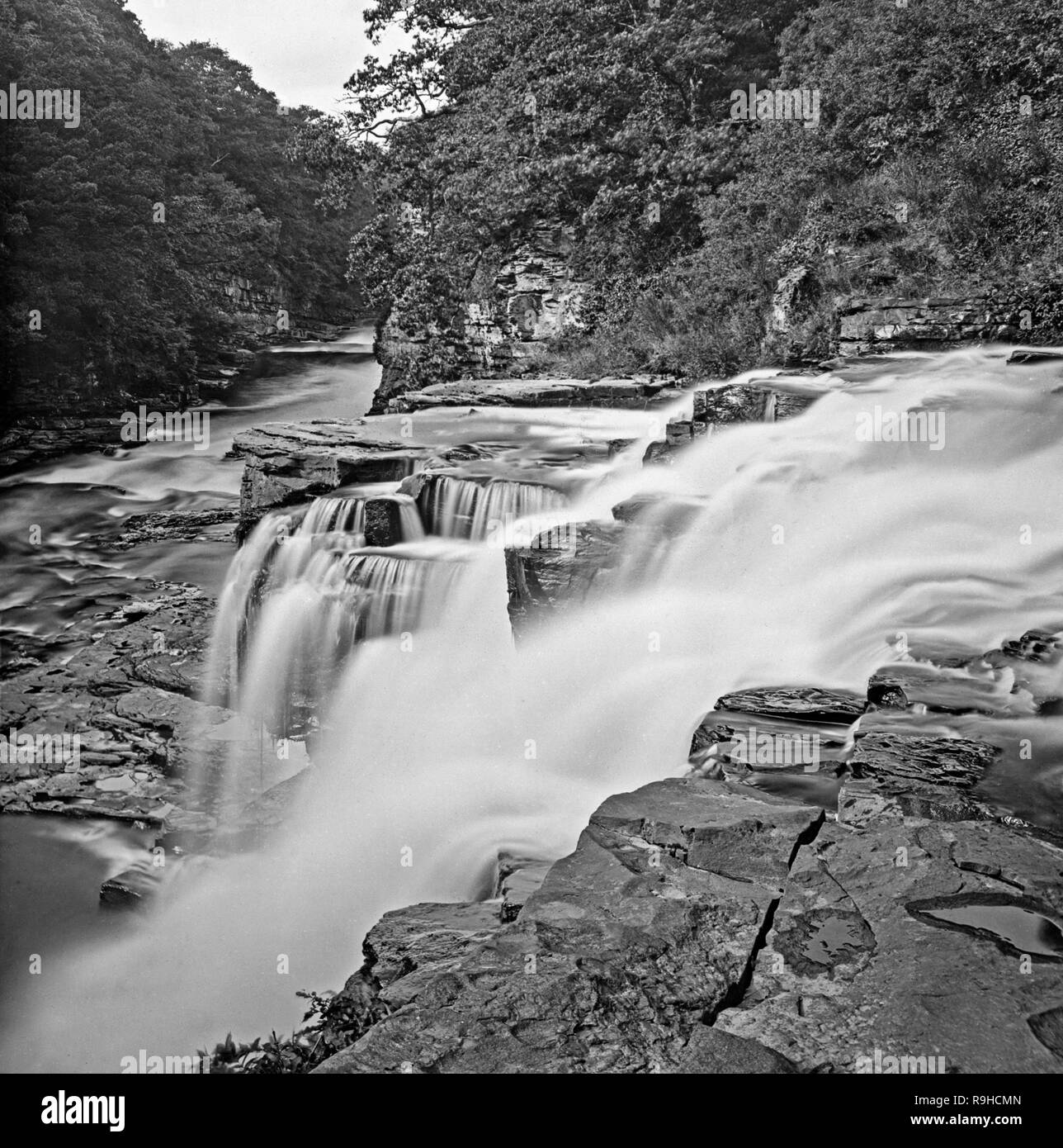 A late Victorian black and white photograph of The Falls Of Clyde.The Falls of Clyde is the collective name of four linn (Scots: waterfalls) on the River Clyde near New Lanark, South Lanarkshire, Scotland. The Falls of Clyde comprise the upper falls of Bonnington Linn, Corra Linn, Dundaff Linn, and the lower falls of Stonebyres Linn. Corra Linn is the highest, with a fall of 84 feet. Bonnington Linn (fall of 30 feet), Corra Linn and Dundaff Linn (fall of 10 feet) are above New Lanark and located within the Falls of Clyde Reserve, now managed by the Scottish Wildlife Trust. Stock Photo