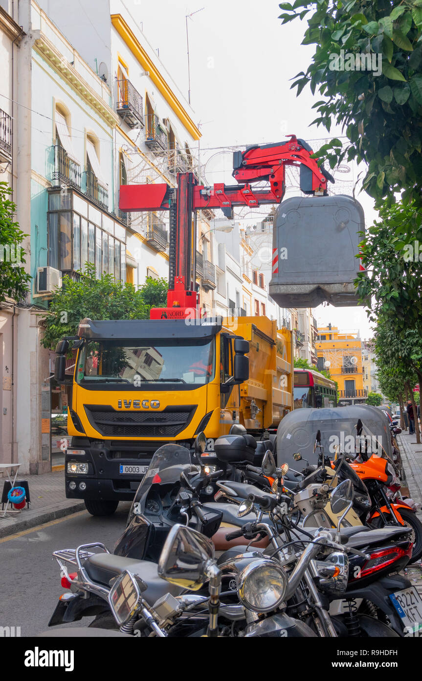 Garbage truck ruck removing large trash containers using a forklift in